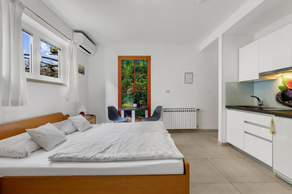 a bedroom with a large bed and a kitchen at Guesthouse Casa Nova in Poreč