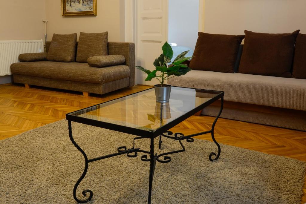 a living room with a glass table and a couch at Demetrovics Udvarház in Eger