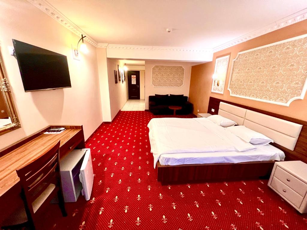 a hotel room with a bed and a flat screen tv at Complex Azar in Galaţi
