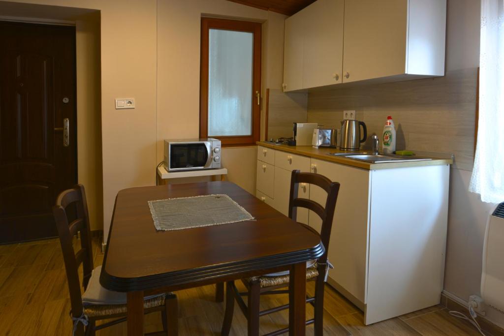 a small kitchen with a table and a microwave at Demetrovics Udvarház in Eger