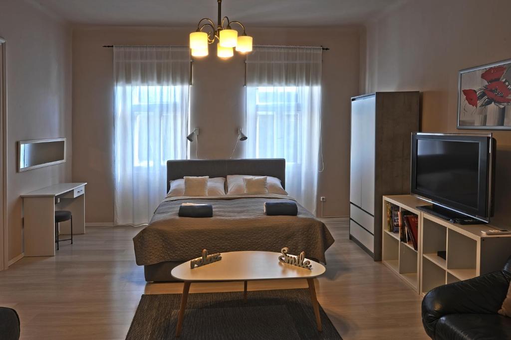 a bedroom with a bed and a tv and a couch at Demetrovics Udvarház in Eger