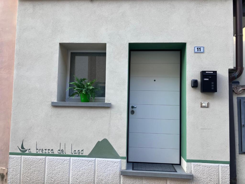 un edificio con una puerta, una ventana y una maceta en La brezza del lago en Marone