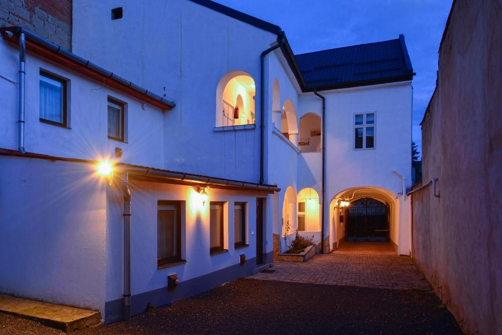 an alley with two white buildings with lights on at Demetrovics Udvarház in Eger