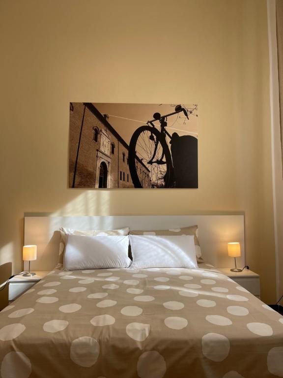 a bedroom with a bed with a bike hanging on the wall at Downtown - Camere in Centro in Ferrara