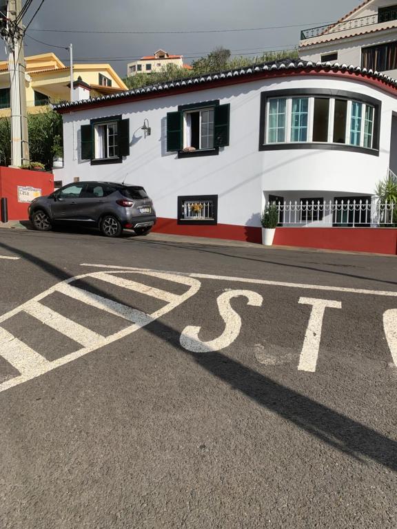 um carro estacionado em frente a um sinal de stop numa rua em Casa 212 em Ponta do Sol