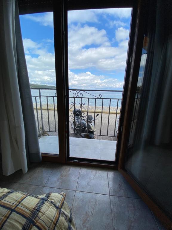 a room with a view of the ocean from a balcony at Δωματια ΞΑΝΘΟΥΛΑ in Amaliapoli