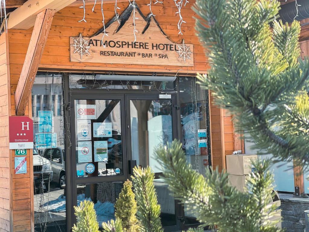 un restaurante con un cartel en la parte delantera de un edificio en Atmosphere Hotel, en Les Deux Alpes
