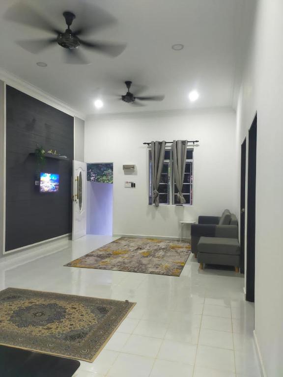 a living room with a couch and a ceiling fan at Homestay ainnor in Pasir Puteh