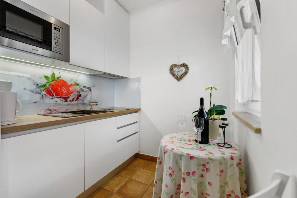 a small kitchen with a table and a microwave at Guesthouse Casa Nova in Poreč