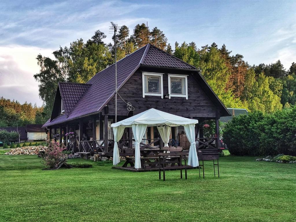 a house with a tent in front of it at Trainiškio pirkia in Ginučiai