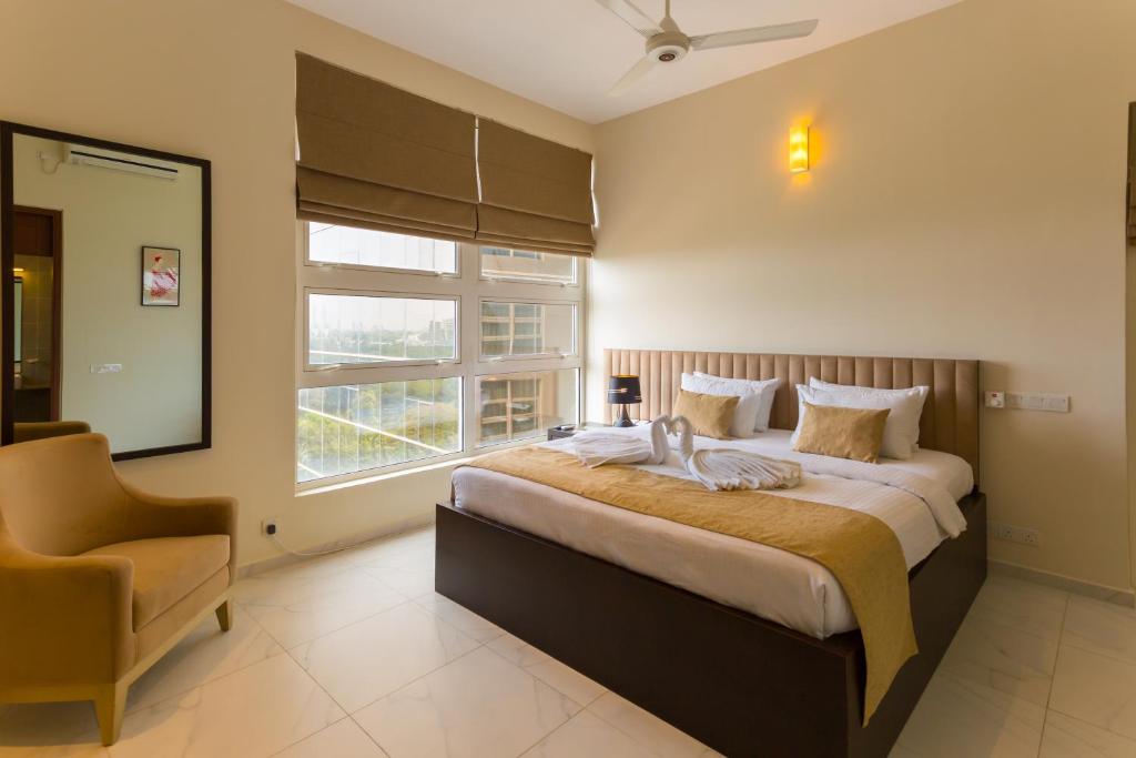 a bedroom with a bed with a chair and a window at Niwahas Apartment Borella in Colombo