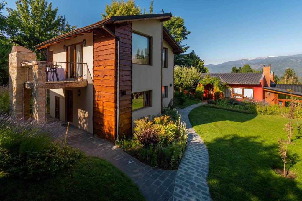 uma casa com um jardim e uma passagem em Sukal em El Bolsón