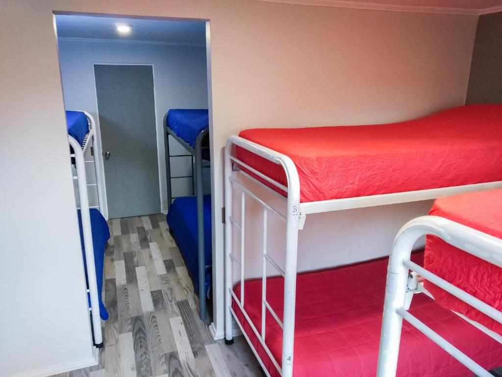 a small room with two bunk beds and a hallway at Aji Hostel in Santiago