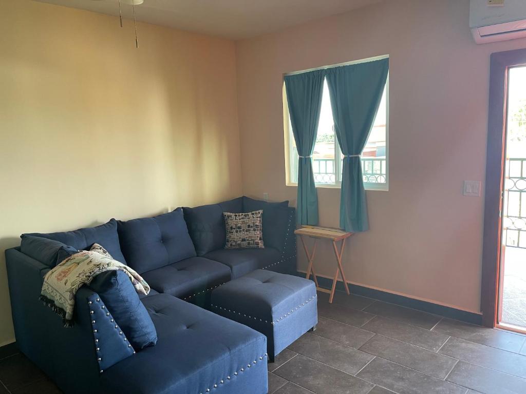 a living room with a blue couch and a window at Condominio puerto peñasco in Puerto Peñasco