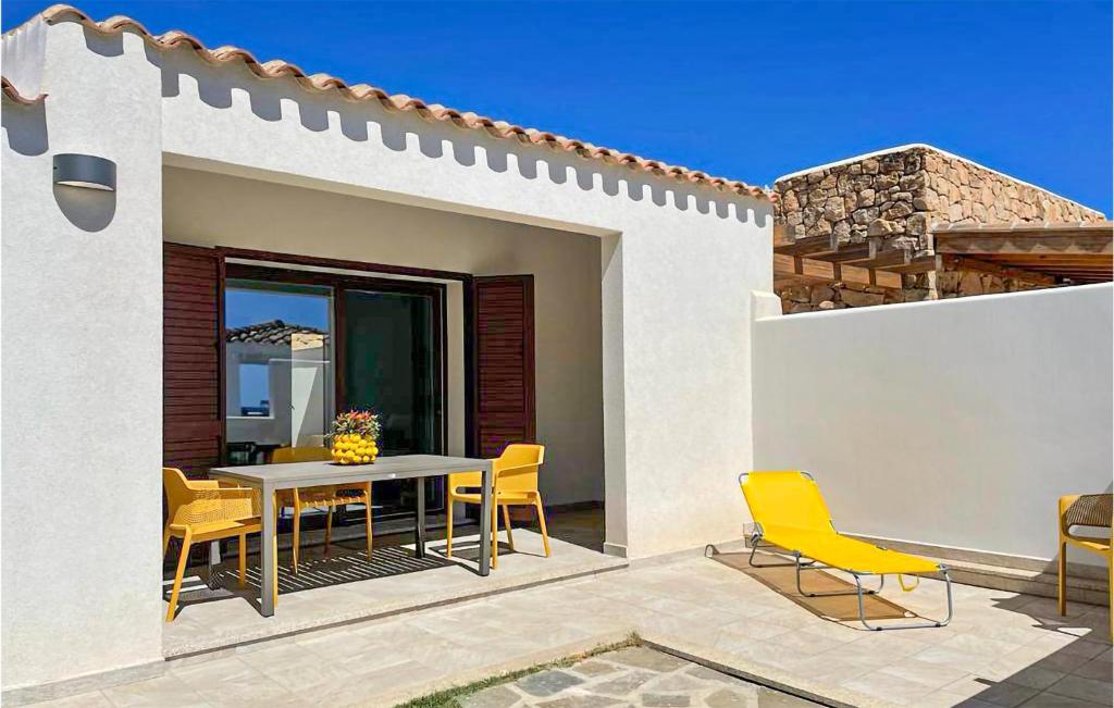 une terrasse avec une table et des chaises dans une maison dans l'établissement 1 Bedroom Stunning Home In Baia S, Anna Budoni, à Tanaunella