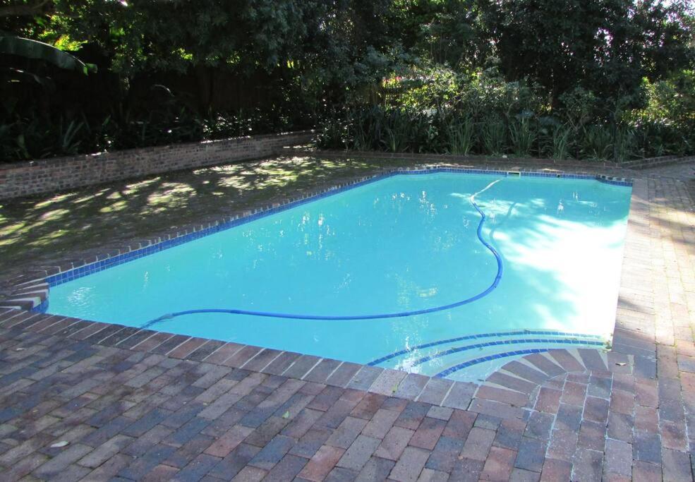 a swimming pool with blue water in a yard at Lovely 1-bedroom rental with a pool in Cape Town