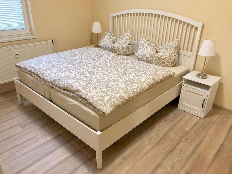 ein weißes Bett mit Kissen darauf im Schlafzimmer in der Unterkunft Ferienwohnung Alte Schule 4 "Hermann Lietz" in Mellenbach-Glasbach