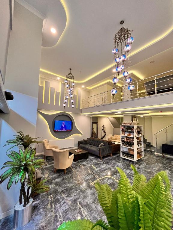 Una sala de estar con un sofá y un televisor. en Şimal Hotel, en Rize