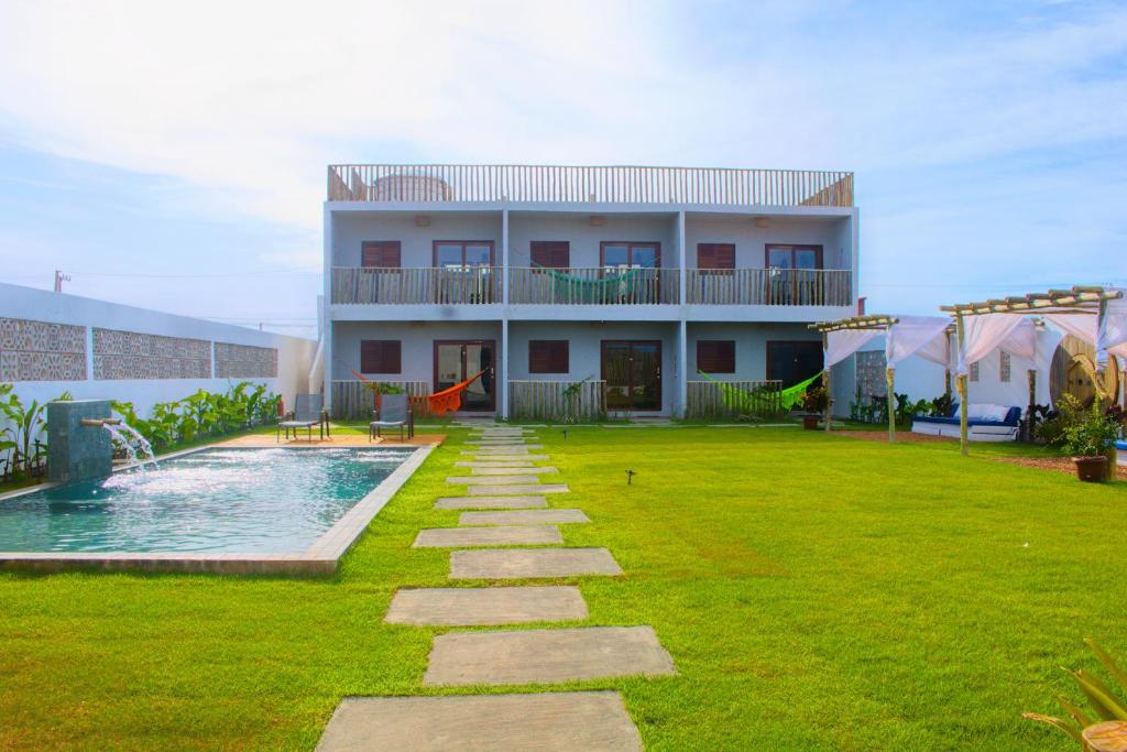 a building with a yard with a swimming pool at Pousada Sal e Sol in São Miguel do Gostoso