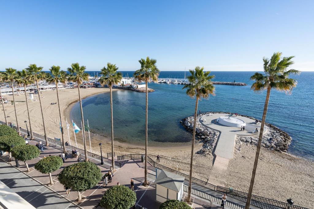 - une vue sur la plage bordée de palmiers et l'océan dans l'établissement Beachfront Studio with Stunning Sea Views, à Marbella