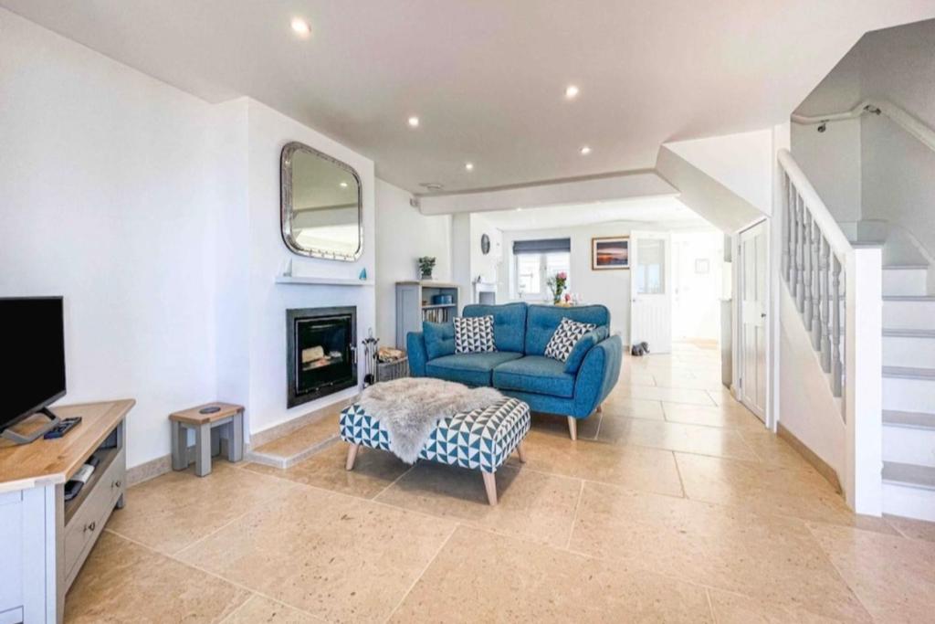 sala de estar con sofá azul y TV en Luxury house with sea view Dorset, Inglaterra, Reino Unido en Radipole
