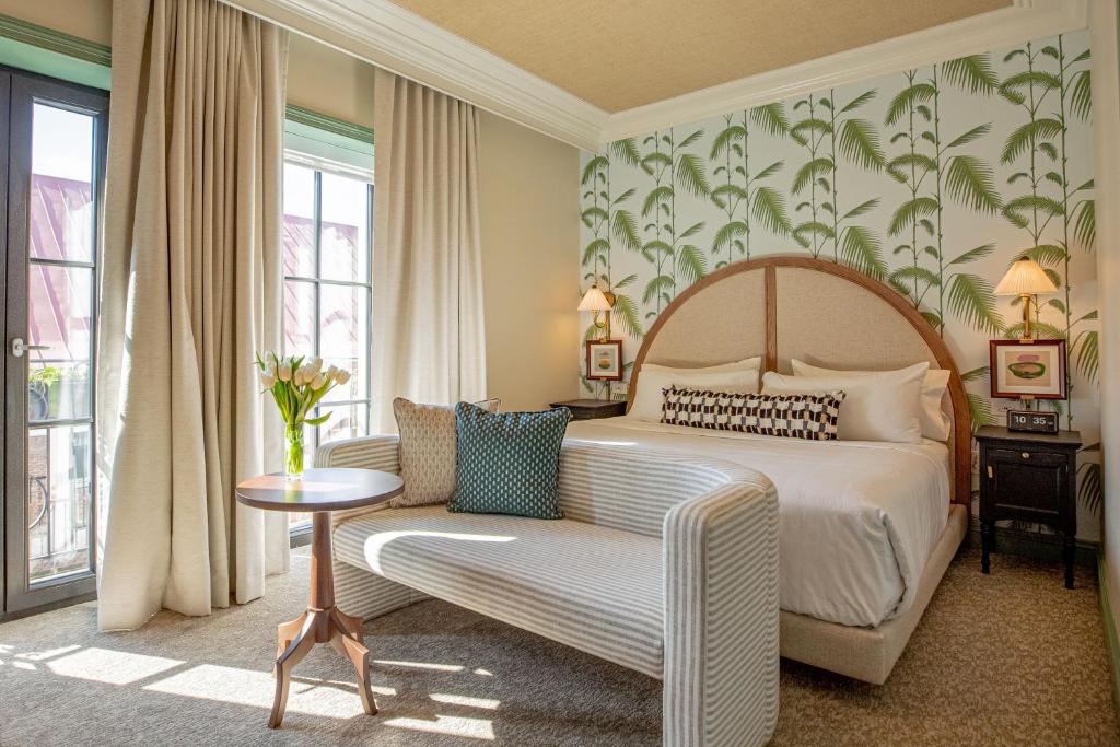 a bedroom with a bed and a couch and a chair at The Palmetto Hotel, Charleston in Charleston