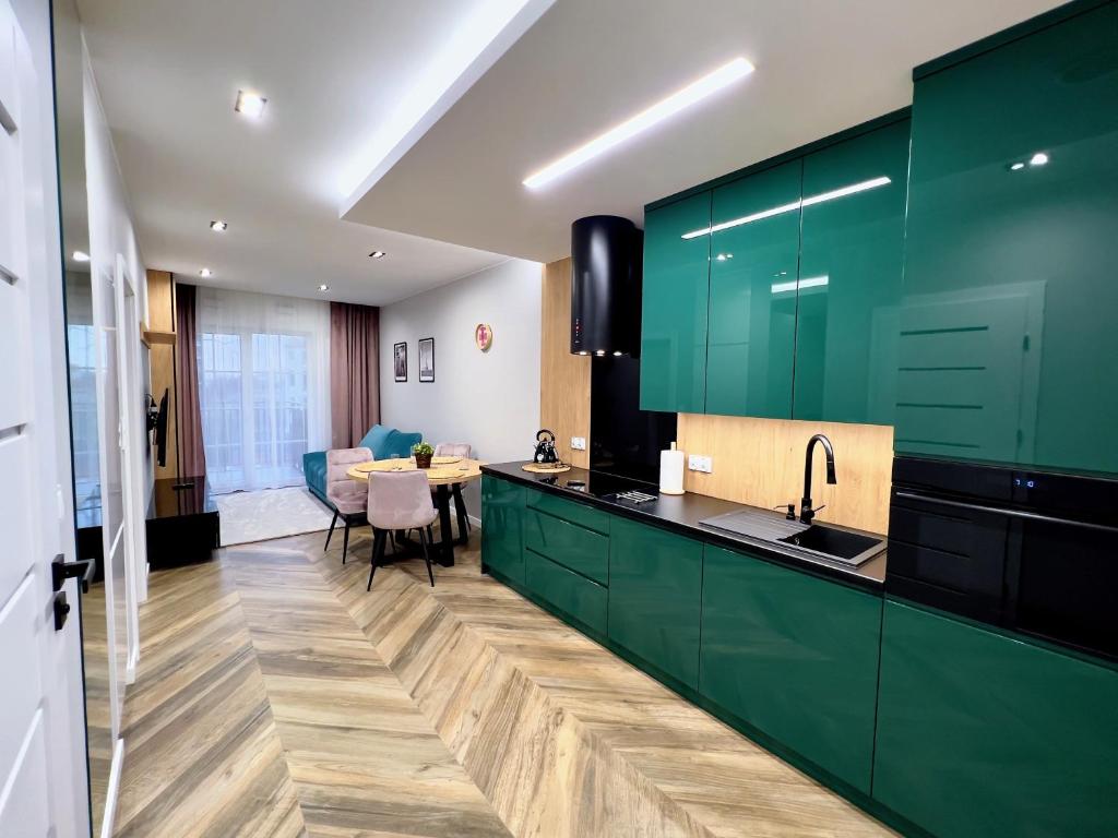 uma cozinha com armários verdes e uma sala de jantar em Luksus w samym centrum em Breslávia