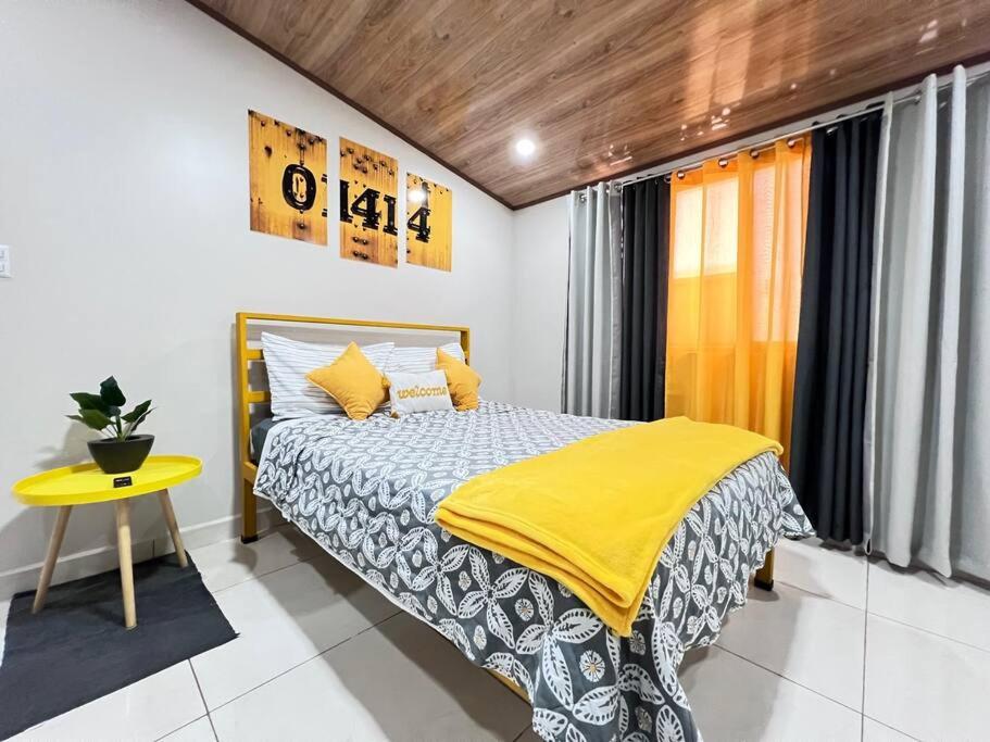 um quarto com uma cama com um cobertor amarelo e uma mesa amarela em MokenPlaceA/C em San Antonio