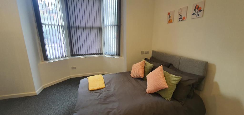 um quarto com uma cama com almofadas em Leicester Central Apartments em Leicester