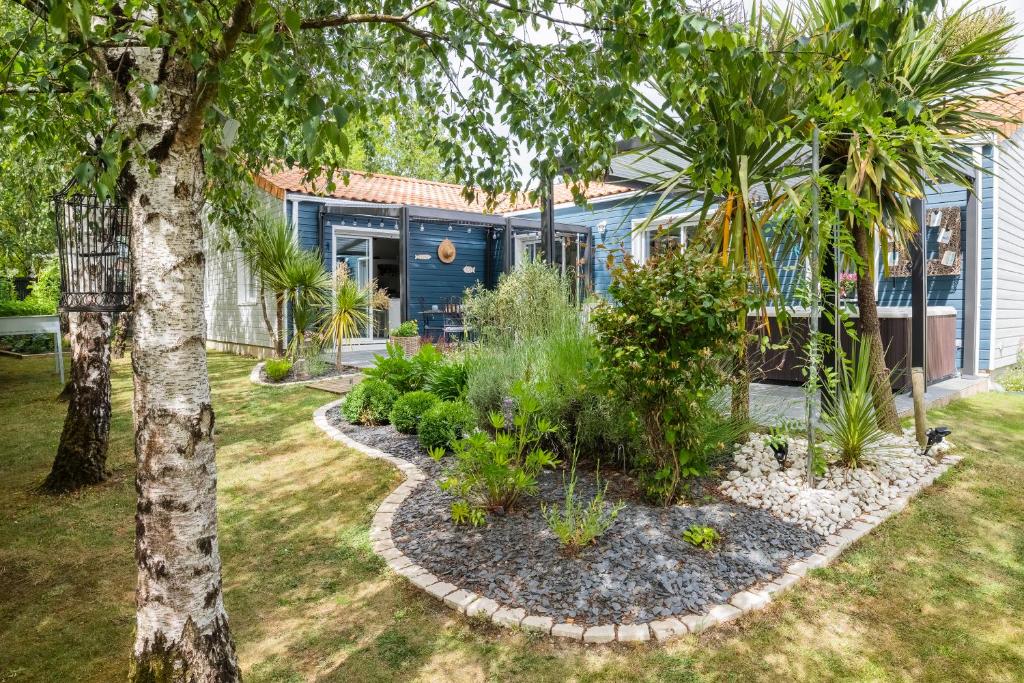 un giardino di fronte a una casa blu con piante di Escale et bien-être a Pornic