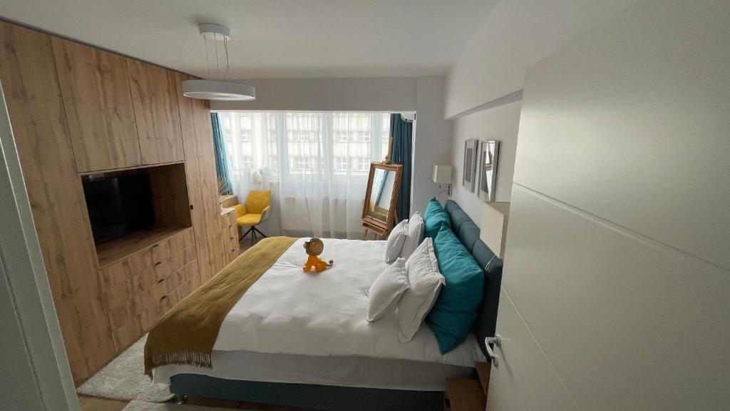 un dormitorio con una cama con un osito de peluche sentado en ella en Luxury Apart Dorobanți, en Bucarest