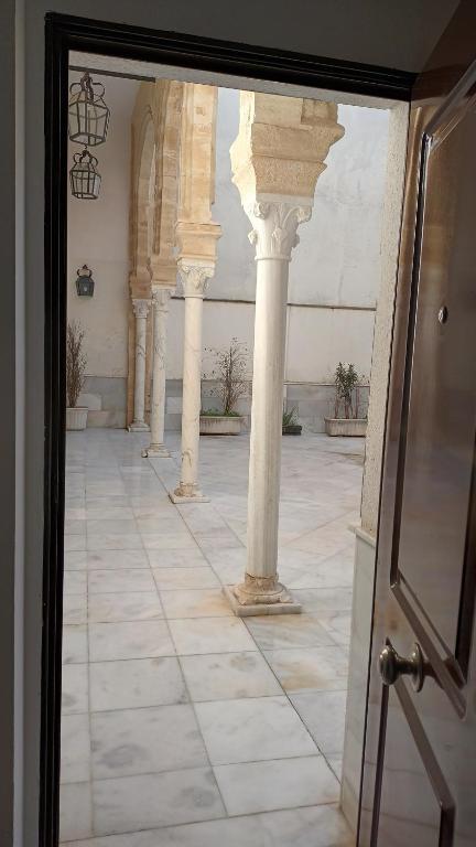 una vista a través de una puerta de cristal de un edificio con columnas en Casa Palacio Arcos del Carmen, en Jerez de la Frontera