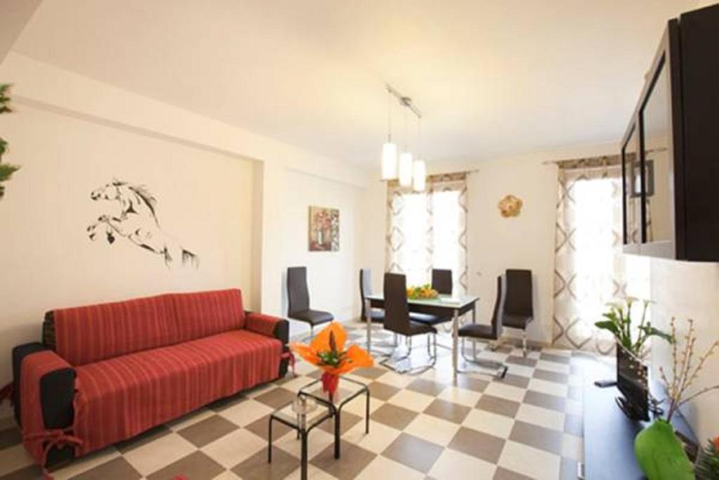 - un salon avec un canapé rouge et une table dans l'établissement Casa Vacanza Nina, à Pozzallo
