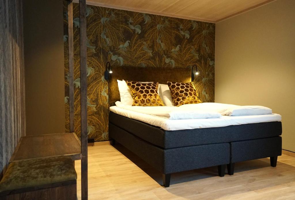 ein Schlafzimmer mit einem Himmelbett mit einer Wand in der Unterkunft Lillehammer Turistsenter Budget Hotel in Lillehammer