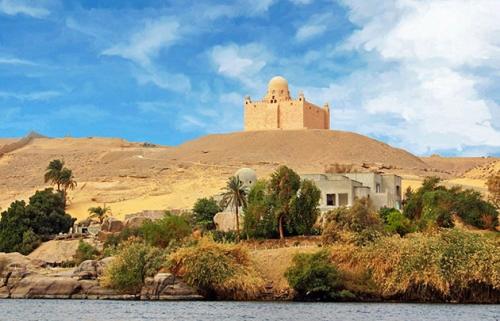 a castle on top of a hill next to a body of water at White House in Aswan