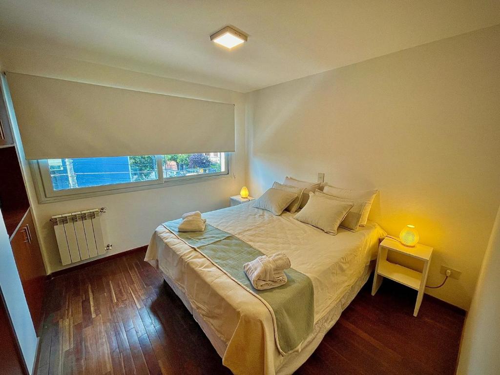 - une chambre avec un grand lit et une fenêtre dans l'établissement Departamento Güemes II, à San Salvador de Jujuy