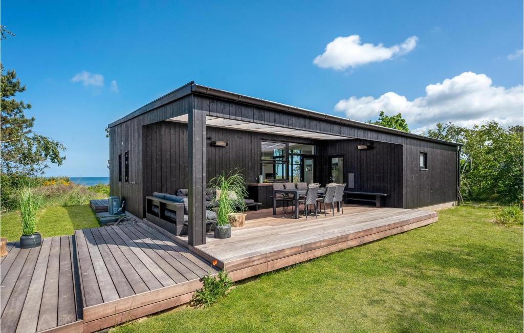 a black container house with a wooden deck at Stunning Home In Kalundborg With House Sea View in Kalundborg