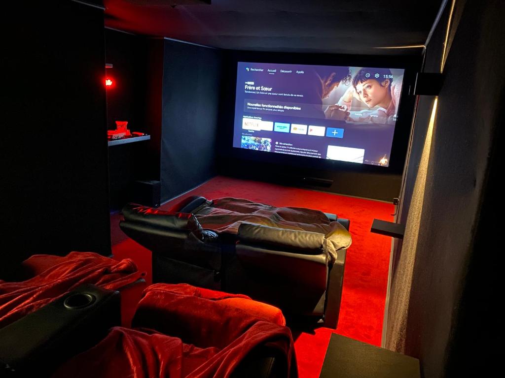 Zimmer mit einem Flachbild-TV und einem Stuhl in der Unterkunft Le ciné'ppart - Easy Life in Bourgoin