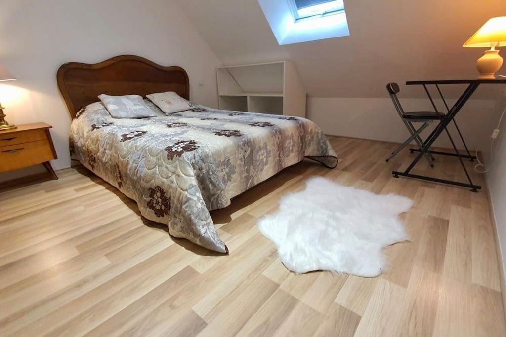 a bedroom with a bed and a white rug on the floor at Lumineux appartement duplex, très bien équipé in Saint-Amand-Montrond