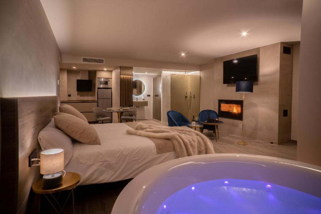 Almazara Suites في الكالا ديل جوكار: غرفة نوم مع سرير وحوض استحمام