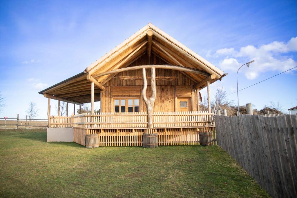 una gran casa de madera con una valla en un patio en Urlaub am Erlebnishof Strasser, 