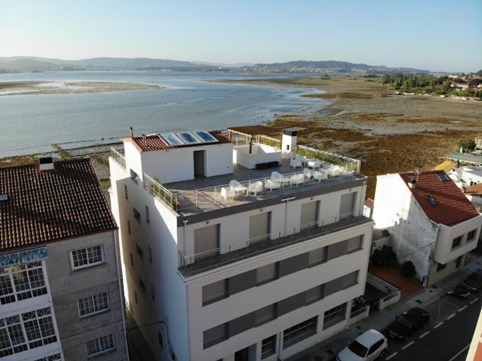 una vista aérea de un edificio junto a una masa de agua en Apartamentos O Grove Awa Bay, en O Grove