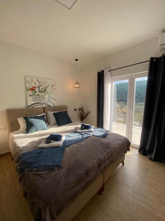 a bedroom with a large bed and a large window at Gold Apartments in Skradin