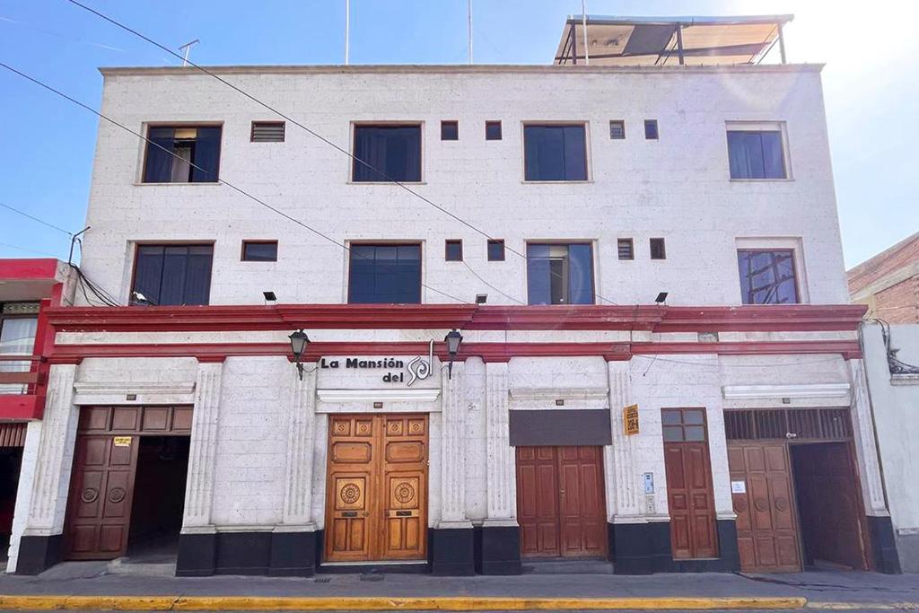 ein großes weißes Gebäude mit vielen Türen in der Unterkunft Hotel La Mansion Del Sol in Arequipa