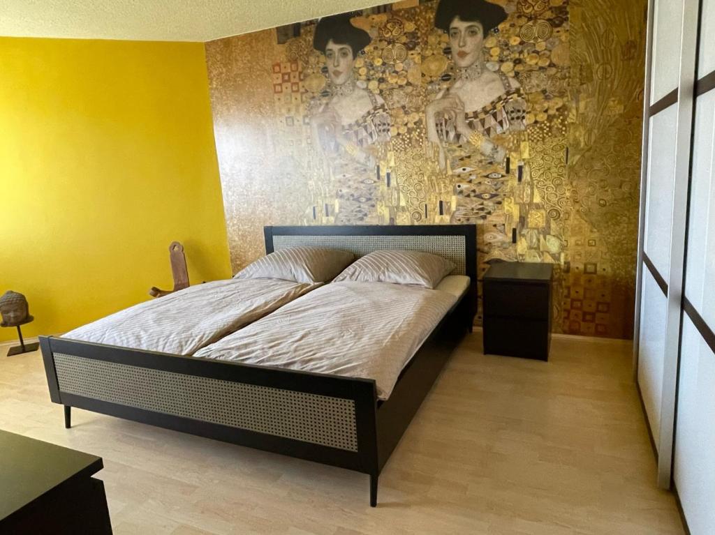 ein Schlafzimmer mit einem Bett und einer Wand mit einem Gemälde in der Unterkunft Zentrale großzügige Dachterassen Whg am Stadtpark in 15 Min mit U-Bahn zur Messe in Nürnberg