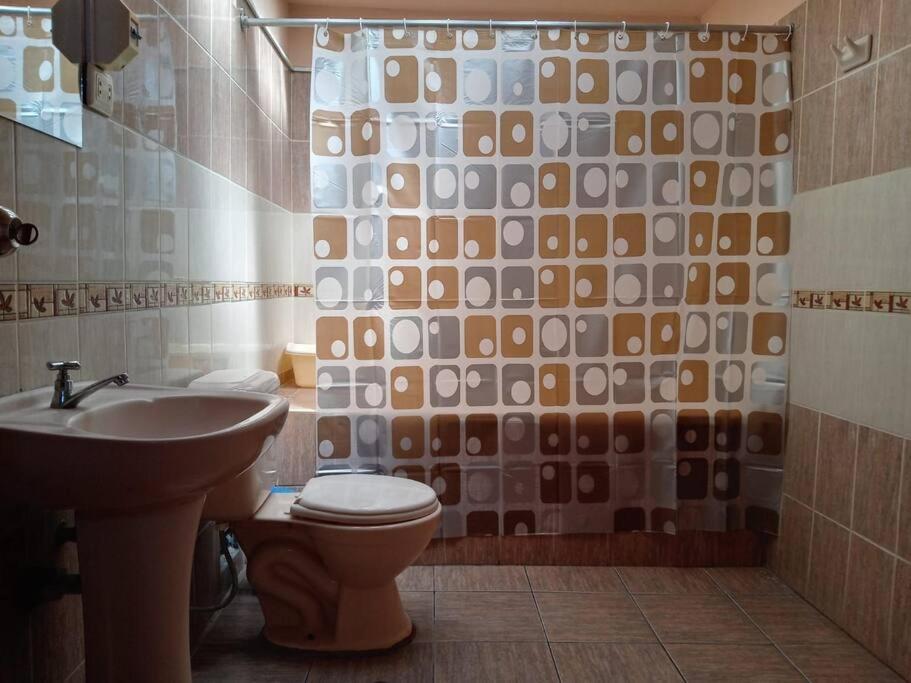 a bathroom with a toilet and a sink at Departamento Independiente en Tacna in Tacna