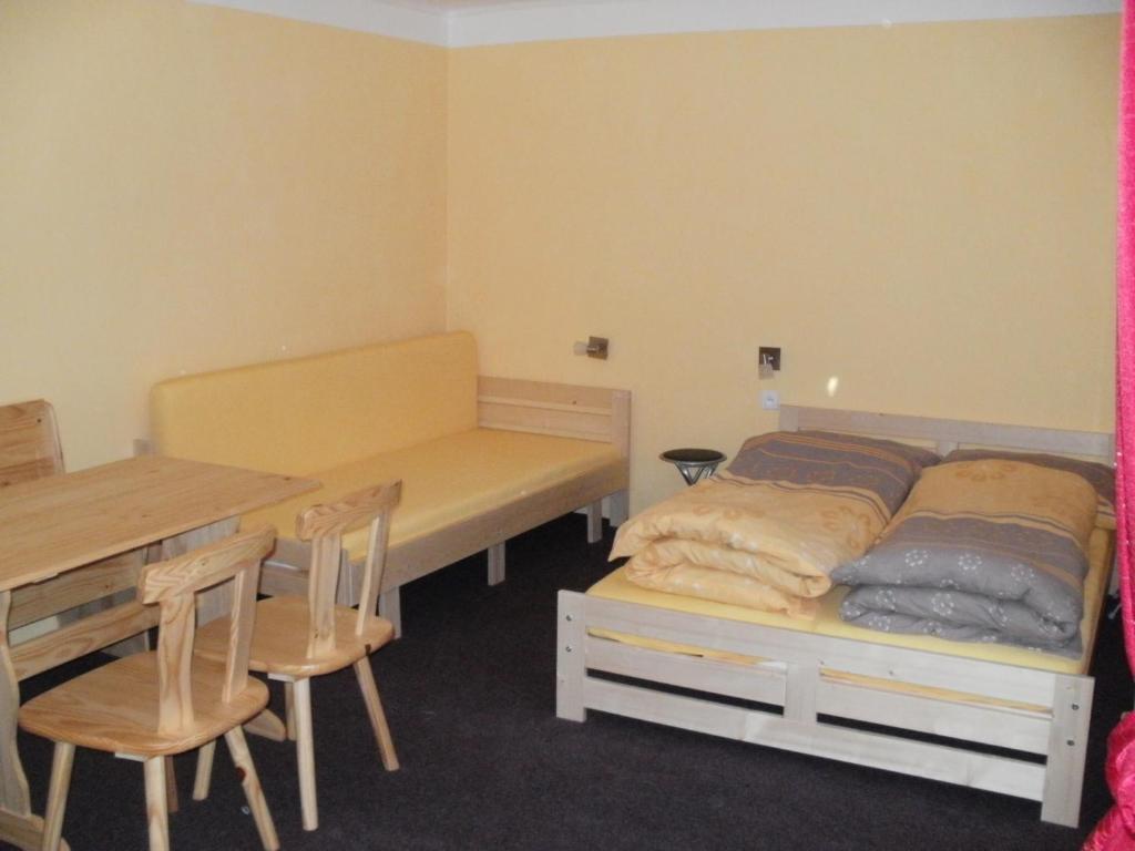Rekreační dům Slavonice في سلافونيتسا: غرفة نوم بسرير وطاولة وكراسي