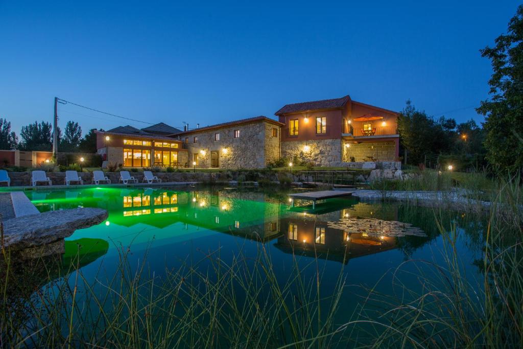 a house with a pond in front of it at night at Quinta do Minhoto in Fafe