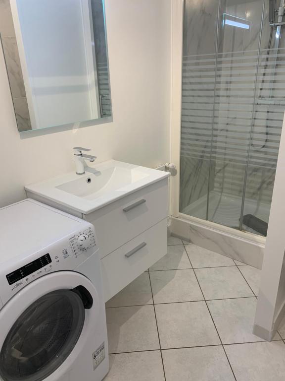 een badkamer met een wasmachine en een wastafel bij Top appartement 2 pièces in La Richardais