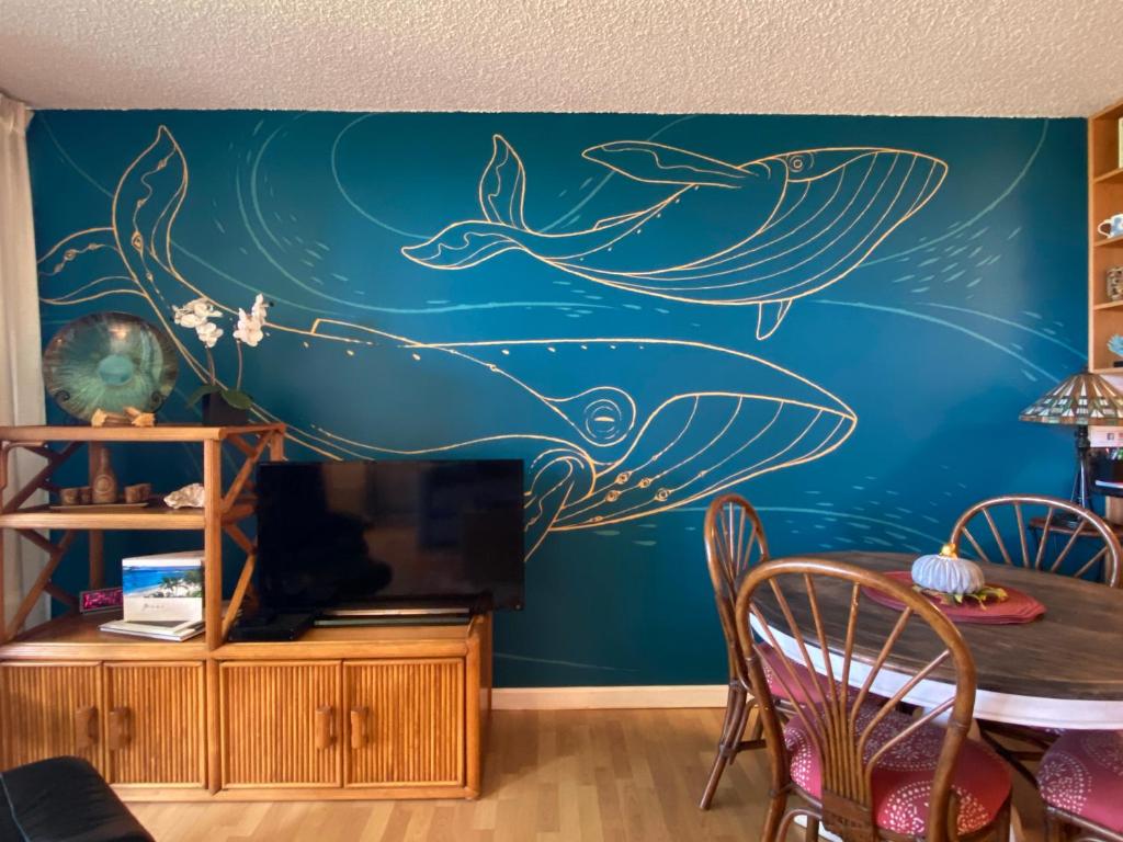 a dining room with a mural of whales on the wall at Maui-LICIOUS by the Beach in Kihei